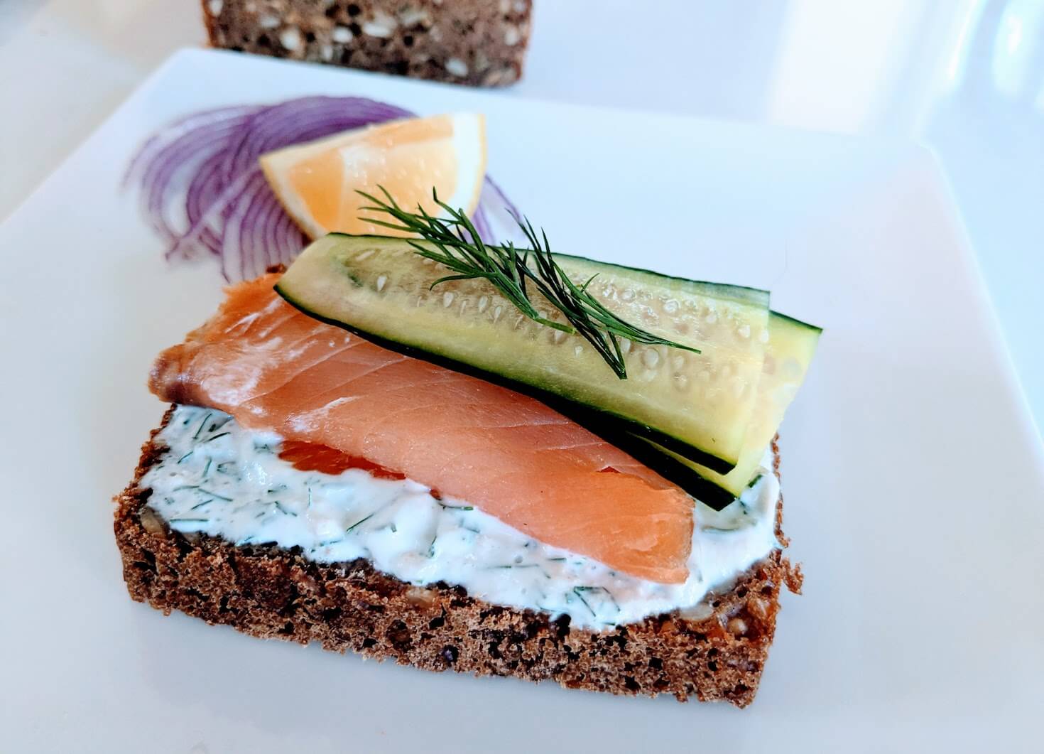 Smorrebrod on Danish rugbrod with salmon, cucumber, and dill