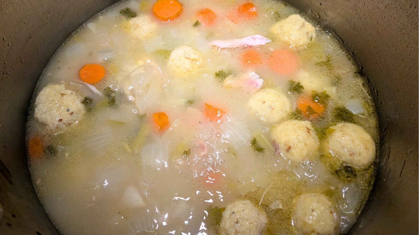 Matzo balls cooking in chicken soup